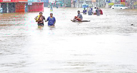People wade through the floodwaters in Aluva town that was submerged after the Periyar breached its banks | Melton Antony