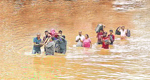 A patient and an elderly woman being rescued by volunteers from a hospital at Aluva on Thursday after water from Periyar river entered it | Melton Antony