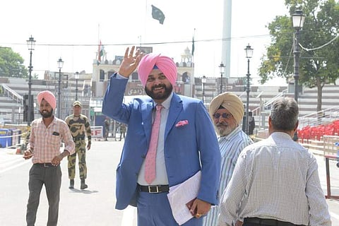 Former Indian cricketer-turned-politician and Punjab Cabinet Minister Navjot Singh Sidhu (C) gestures as he crosses the India Pakistan border in Wagah. (Photo | AFP)