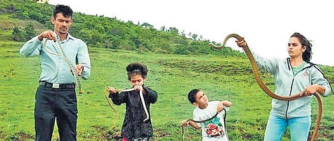 Anand Chitti along with Nirzara and their two children handling snakes in Belagavi | Express