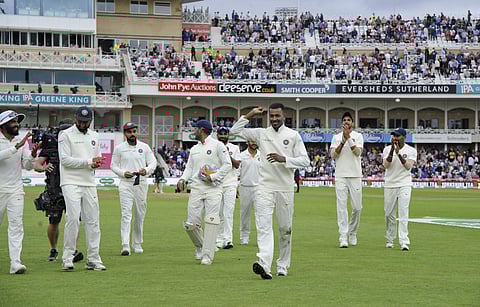 Indian cricketers applaud teammate India's Hardik Pandya, holding ball, for taking five wickets, as they leave the field | AP