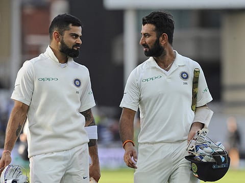 Indian cricket captain Virat Kohli, left, and Cheteshwar Pujara leave the field at the end of the day's play | AP