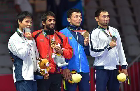 India's Bajrang Punia poses with gold medal after winning in the Finals of men's freestyle wrestling 65kg against Japan's Daichi Takatani | PTI