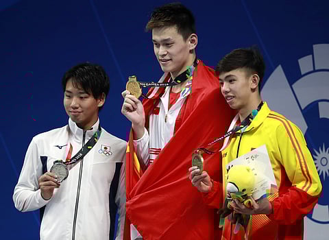 Gold medalist China's Sun Yang, centre, stands with silver medalist Japan's Shogo Takeda, left, and bronze medalist Vietnam's Huy Hoang Nguyen after winning the men's 800m freestyle final | AP