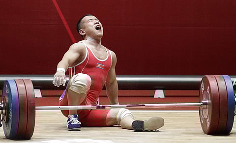 North Korean Om Yun Chol reacts on his last attempt to break his own record for the men's 56kg weightlifting at the 18th Asian Games in Jakarta, Indonesia on Monday, Aug. 20, 2018. | AP