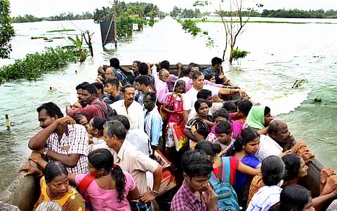 Kerala floods: People who got stranded in the marooned Kumarakom panchayat are being shifted to Kottayam in a Taurus lorry. Kumarakom is seen behind as an extension of Vembanadu backwaters. (Photo | Vishnu Prathap/EPS)