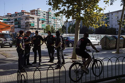 Catalan police officers stand near a police station, following an attack in Cornella de Llobregat near Barcelona. (Photo | AP)
