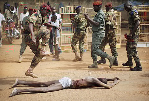 In this Wednesday Feb 5, 2014 photo, a Central African Armed Forces officer jumps on the lifeless body of a suspected Muslim Seleka militiaman (FIle | AP)
