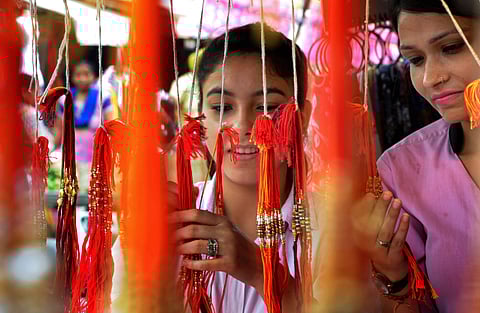 Prior to the Raksha Bandhan festival, people buying rakhis from street vendors. (Photo|PTI)