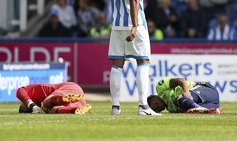 Huddersfield Town goalkeeper Ben Hamer and Cardiff City's Nathaniel Mendez-Laing lay on the ground injured after colliding with each other | AP