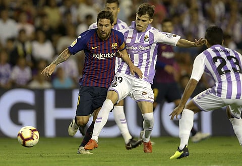 Barcelona's Lionel Messi fights for the ball against Valladolid Toni Villa during the Spanish La Liga soccer match between FC Barcelona and Valladolid at the Nuevo Jose Zorrilla stadium in Valladolid. | AP