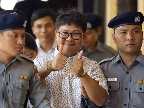 Reuters journalist Wa Lone, center, thumbs up as he is escorted by police upon arrival at the court for trial in Yangon, Myanmar Friday, April 20, 2018. (File | AP)