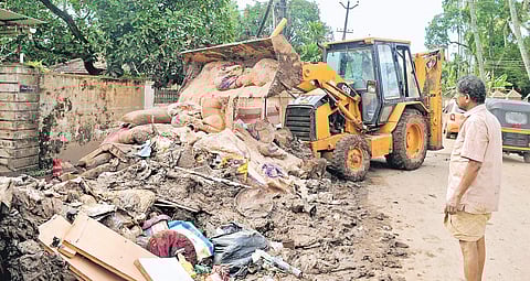 Sacks of wet grain from a ration shop being dumped on the street in Aluva | A Sanesh