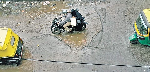 A huge rainwater-filled pothole at Shivajinagar in Bengaluru on Monday | Pandarinath B