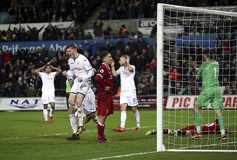 Swansea City's Alfie Mawson, left, celebrates in the final moments of the English Premier League soccer match between Swansea City and Liverpool, at the Liberty Stadium, in Swansea. (File Photo | AP)