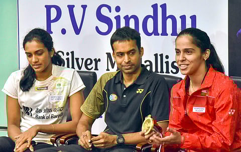 Indian badminton coach P Gopichand flanked by Asian Games Silver medallist PV Sindhu and Bronze medallist Saina Nehwal address a press conference in Hyderabad. (Photo | AP)