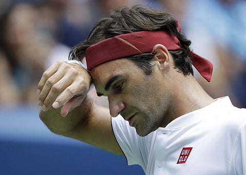 Roger Federer of Switzerland wipes his face against Benoit Paire, of France, during the second round of the US Open | AP