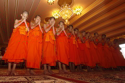 Members of Wild Boars soccer team pray during a ceremony marking the completion of their serving as novice Buddhist monks, following their dramatic rescue from a cave in Mae Sai district, Chiang Rai province, northern Thailand, Saturday, Aug. 4, 2018. (Ph