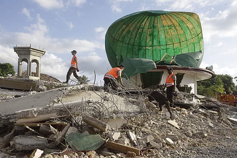Rescuers with sniffer dog search for victims at a mosque damaged by an earthquake in North Lombok, Indonesia. (Photo | AP)