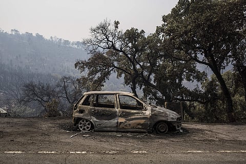 A burnt car lies abandoned. (Photo| AP)