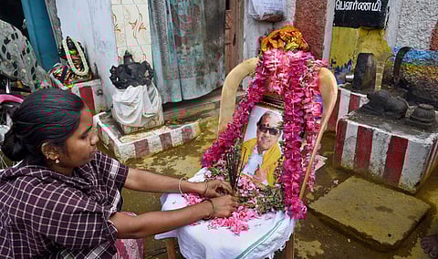 Women seen conducting Pooja to late DMK chief Karunanidhi's photo in front of a teample at Ukkadam in Coimbatore on Wednesday. | (A Raja Chidambaram | EPS)