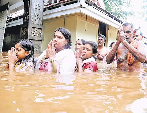 Devotees having a dip in the flooded water marking the arattu of Thanikkudam Bhagavathi temple  in Thrissur on Wednesday | Express