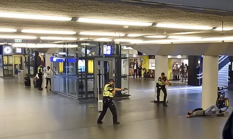 Dutch police officers point their guns at a wounded 19-year-old man who was shot by police after stabbing two people in the central railway station in Amsterdam, the Netherlands, Friday Aug. 31, 2018. (Photo | AP)