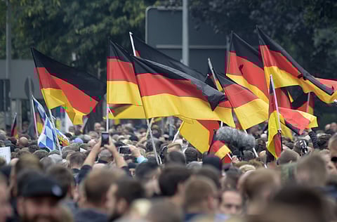 Demonstrators carry German flags during a demonstration in Chemnitz. (Photo | AP)