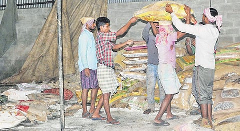 Workers clear out rotten rice from Ameen Traders at Thottumukkam  | A Sanesh