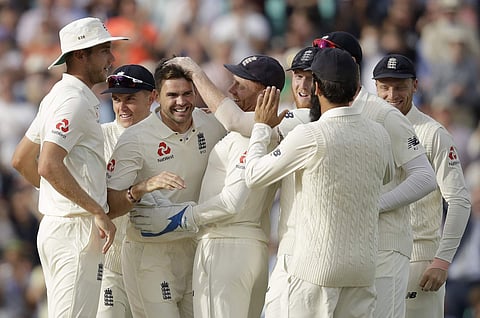 England's Jimmy Anderson, third left, celebrates with his teammates after taking the wicket of India's Cheteshwar Pujara to equal the most number of wickets ever taken by a pace bowler during the fifth cricket test match between England and India at the O