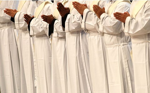 Priests pray during a ceremony in St. Peter's Basilica at the Vatican, Sunday, April 22, 2018. (AP)