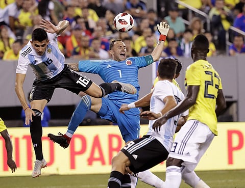 Colombia goalkeeper David Ospina, center, reacts after deflecting a pass intended for Argentina's Rodrigo Battaglia, left, during the second half of a international soccer friendly match