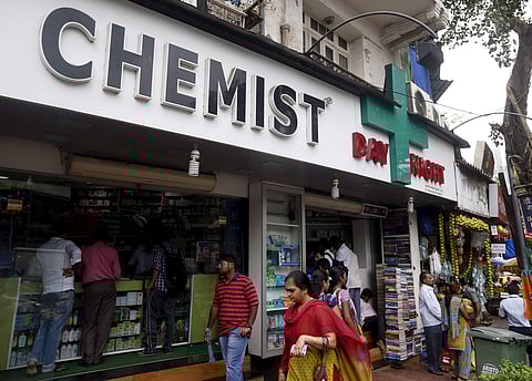 People walk past a chemist shop at a market in Mumbai. (File | Reuters)