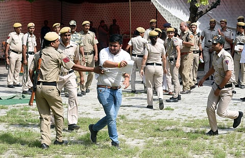 NSUI leader forcibly coming out of a room where the police had detained them following a protest in connection with DUSU elections at counting station in DU. (Photo | EPS)