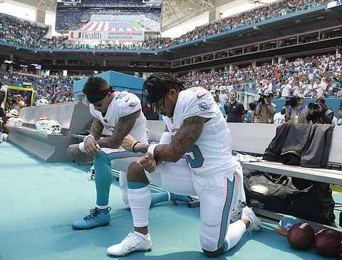 Miami Dolphins wide receiver Kenny Stills (10) and wide receiver Albert Wilson (15) kneel during the national anthem before an NFL football game against the Tennessee Titans | AP