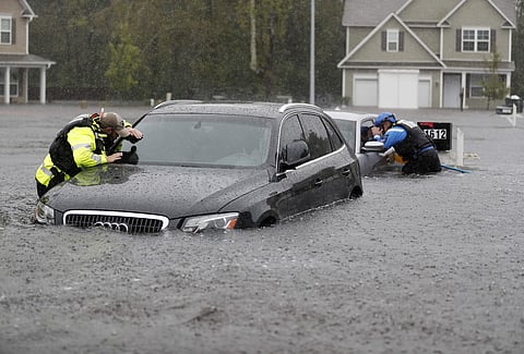 Members of the North Carolina Task Force urban search and rescue team check cars in a flooded neighborhood looking for residents who stayed behind as Florence continues to dump heavy rain in NC | AP