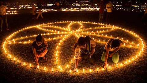 People lighting earthern lamps on the bank of River Saryu for Diwali