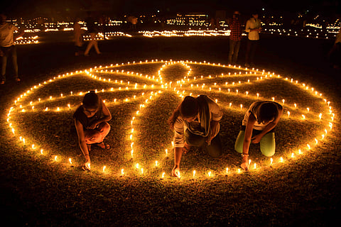 People lighting earthern lamps on the bank of river Saryu for Diwali in 2017