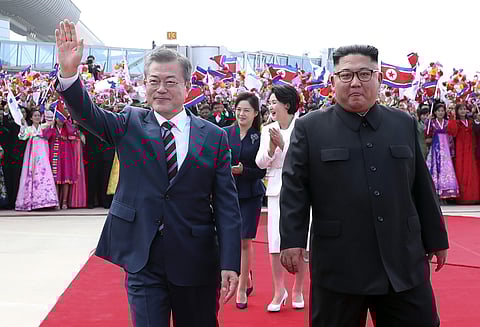South Korean President Moon Jae-in, left, waves while walking with North Korean leader Kim Jong Un during a welcome ceremony at Sunan International Airport in Pyongyang, North Korea, Tuesday, Sept. 18, 2018. (Photo | AP)