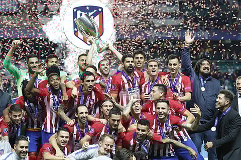 Atletico's team members celebrate with trophy after the UEFA Super Cup final soccer match between Real Madrid and Atletico Madrid at the Lillekula Stadium in Tallinn, Estonia. (Photo | AP)