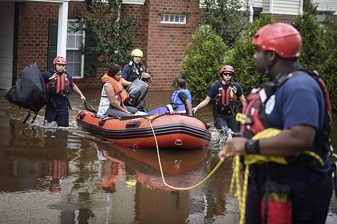 Emergency personnel take a family to safety after Little River overflowed its banks and flooded part of the apartment complex on Monday, Sept. 17, 2018, in Spring Lake, N.C. North Carolina Government Roy Cooper warned that the flooding set off by rain from Florence is far from over and will get worse in places. ( Photo | AP)