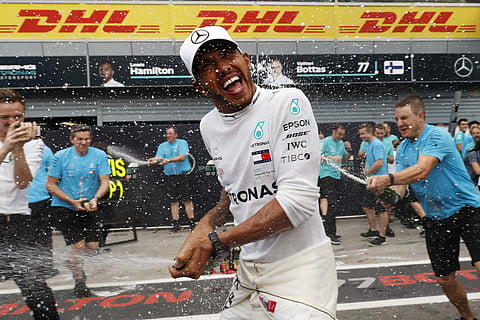 Mercedes team members spray champagne at Mercedes driver Lewis Hamilton of Britain celebrating after winning the Formula One Italy Grand Prix at the Monza racetrack, in Monza. | AP