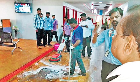 KSPCB Chairman Laxman was shown that the water used to clean the floor at RxDx Hospital, located opposite Graphite India, turns black. Residents claim this is due to the soot emitted from the factory  | Express