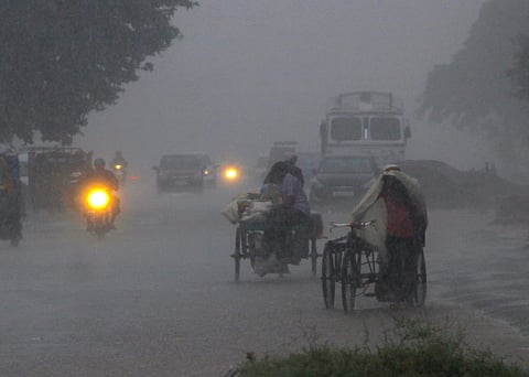 A rickshaw puller walks alongside his vehicle during heavy rainfall, in Bhubaneswar. Cyclonic storm 'Daye' caused heavy rainfall in several parts of Odisha on Friday. (Photo | PTI)