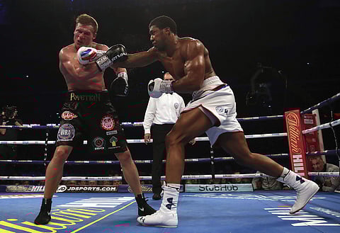 Britain's Anthony Joshua, right, lands a blow on Alexander Povetkin on his way to retaining his WBA, IBF, and WBO heavyweight boxing titles. (Photo | AP)