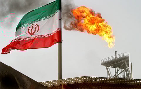 A gas flare on an oil production platform in the Soroush oil fields is seen alongside an Iranian flag in the Persia, Gulf, Iran. (Photo | Reuters)