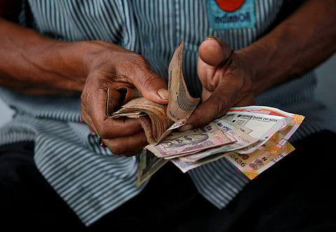 File Photo of An attendant at a fuel station arranges Indian rupee notes in Kolkata, India, August 16, 2018. (Photo | Reuters)
