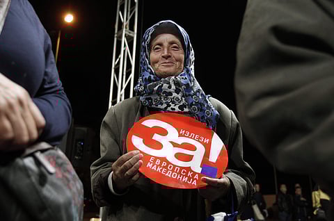 A woman holds a poster reading 'Come out for European Macedonia', during the final pre-referendum rally of the coalition 'For European Macedonia', in Macedonia's western town of Tetovo, Thursday, Sept. 27, 2018. (Photo | AP)