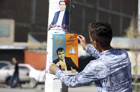 An Afghan man hangs an election poster of the parliamentary candidate Khan Ali Radmand during the first day of election campaigning in Kabul, Afghanistan, Sept. 28, 2018. (Photo | AP)