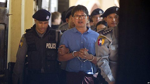 Reuters journalist Wa Lone is escorted by police as he leaves court outside Yangon, Myanmar. (Photo | AP)